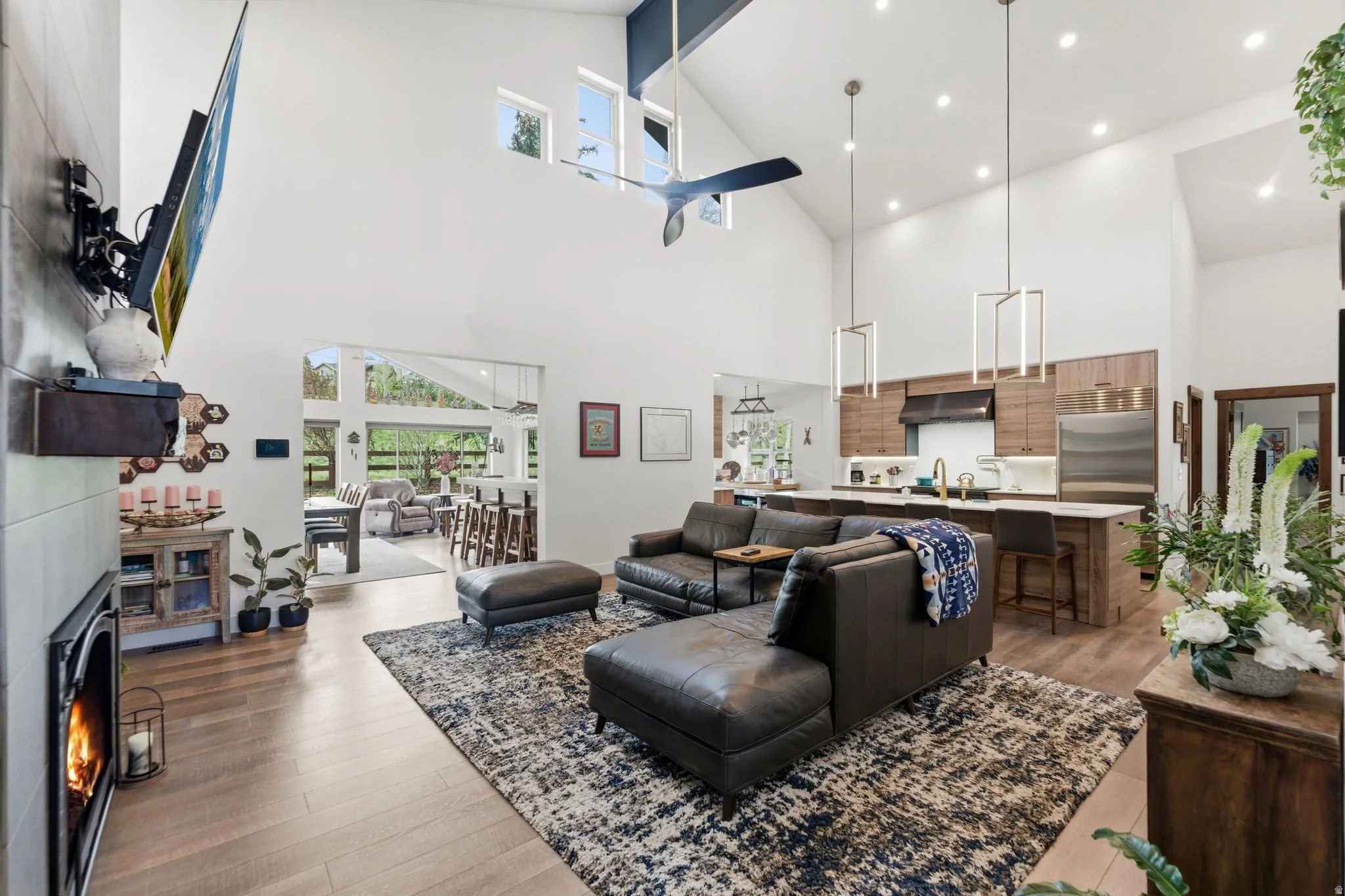 Living room featuring dark wood finished floors, a lit fireplace, vaulted ceiling, and recessed lighting