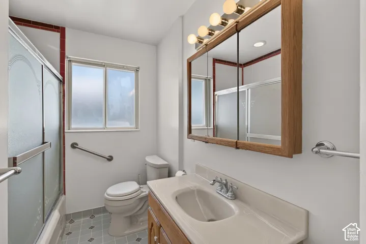 Bathroom featuring a wood-finish vanity with an integrated sink, a rectangular mirrored medicine cabinet, and a five-light vanity fixture