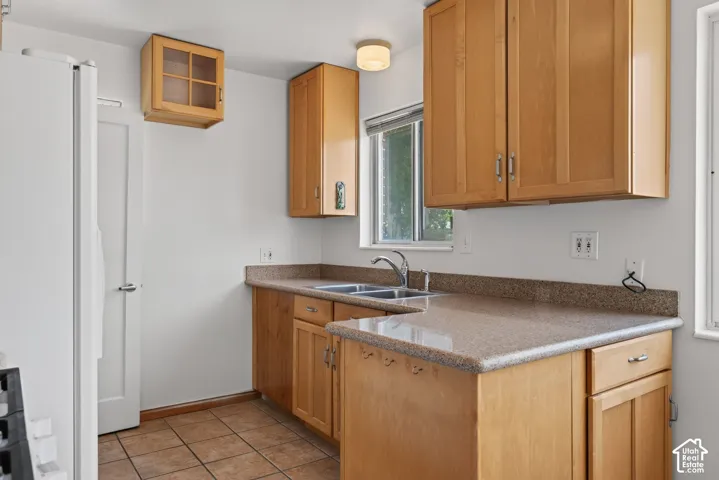 Kitchen featuring light wood cabinetry, stone-finish countertops, and ceramic tile flooring