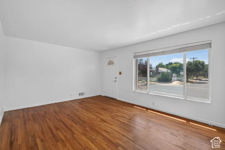 Spacious interior with wood-finish flooring, white walls, and a large multi-pane window