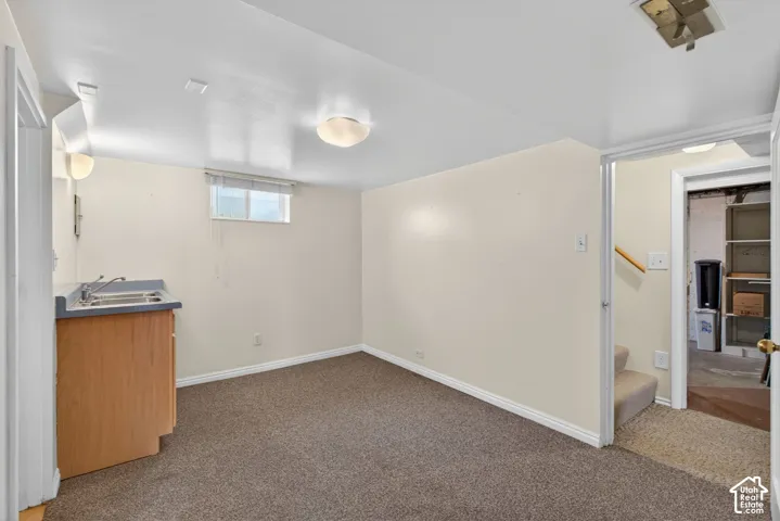 Basement featuring dark carpet and a sink