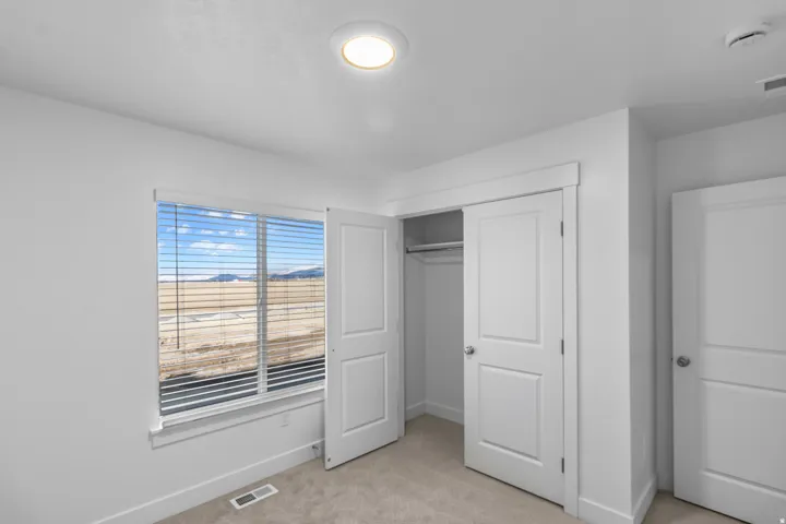 Unfurnished bedroom featuring light carpet and a closet