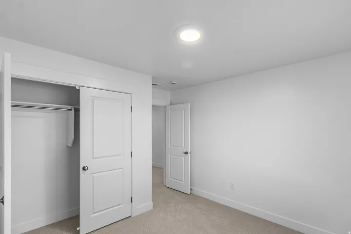 Unfurnished bedroom featuring light colored carpet and a closet