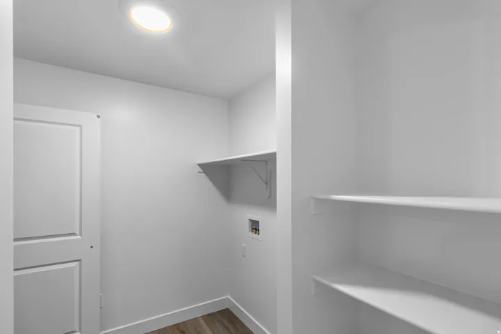Laundry area with dark wood-type flooring and hookup for a washing machine
