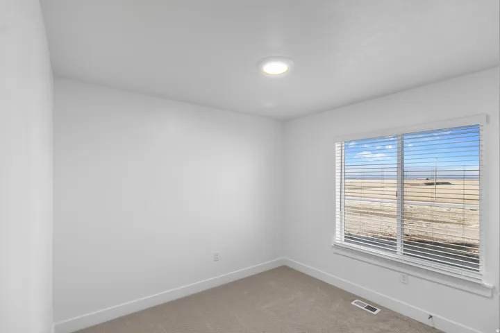Carpeted spare room featuring baseboards