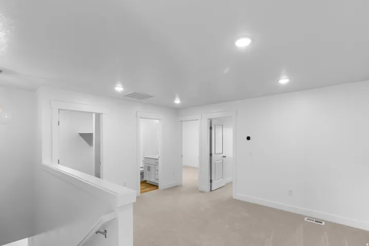 Below grade area with light carpet and recessed lighting