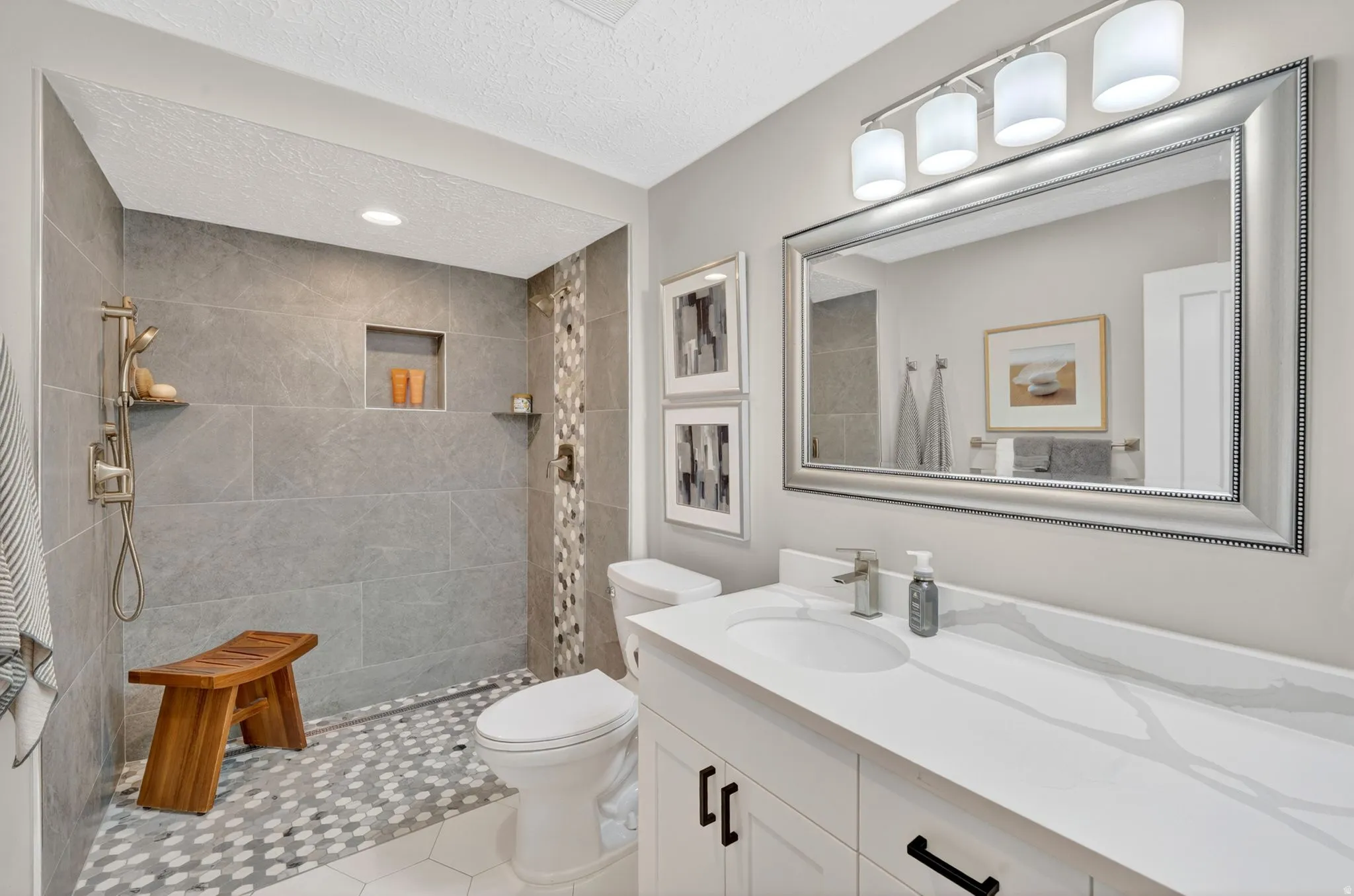 Full bathroom featuring vanity, walk in shower, and a textured ceiling
