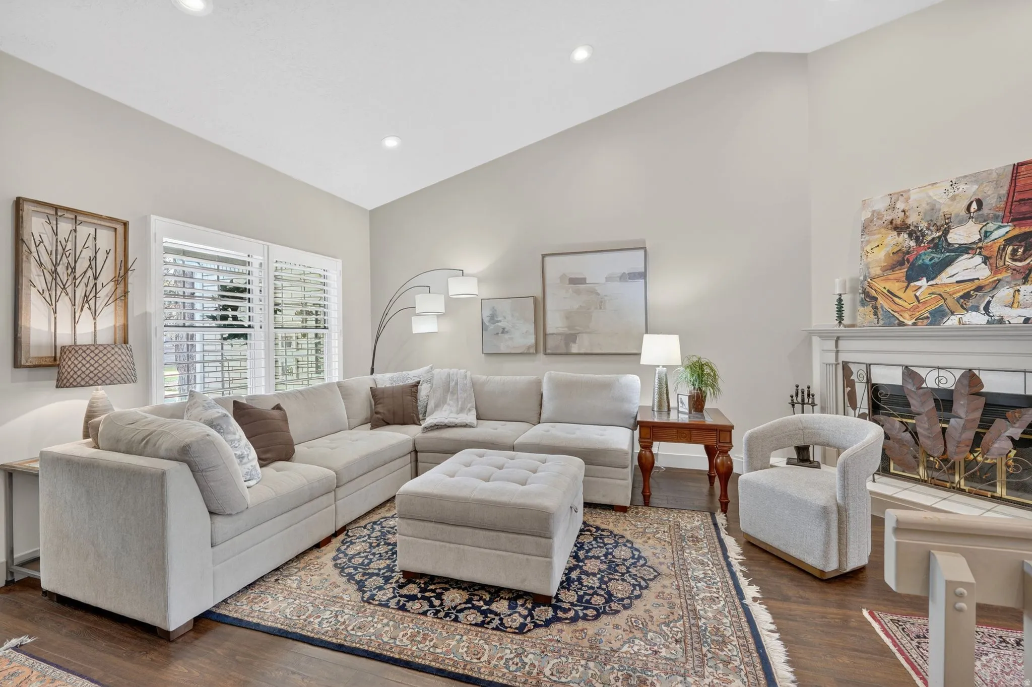 Living area featuring a fireplace, dark wood-style floors, vaulted ceiling, and recessed lighting