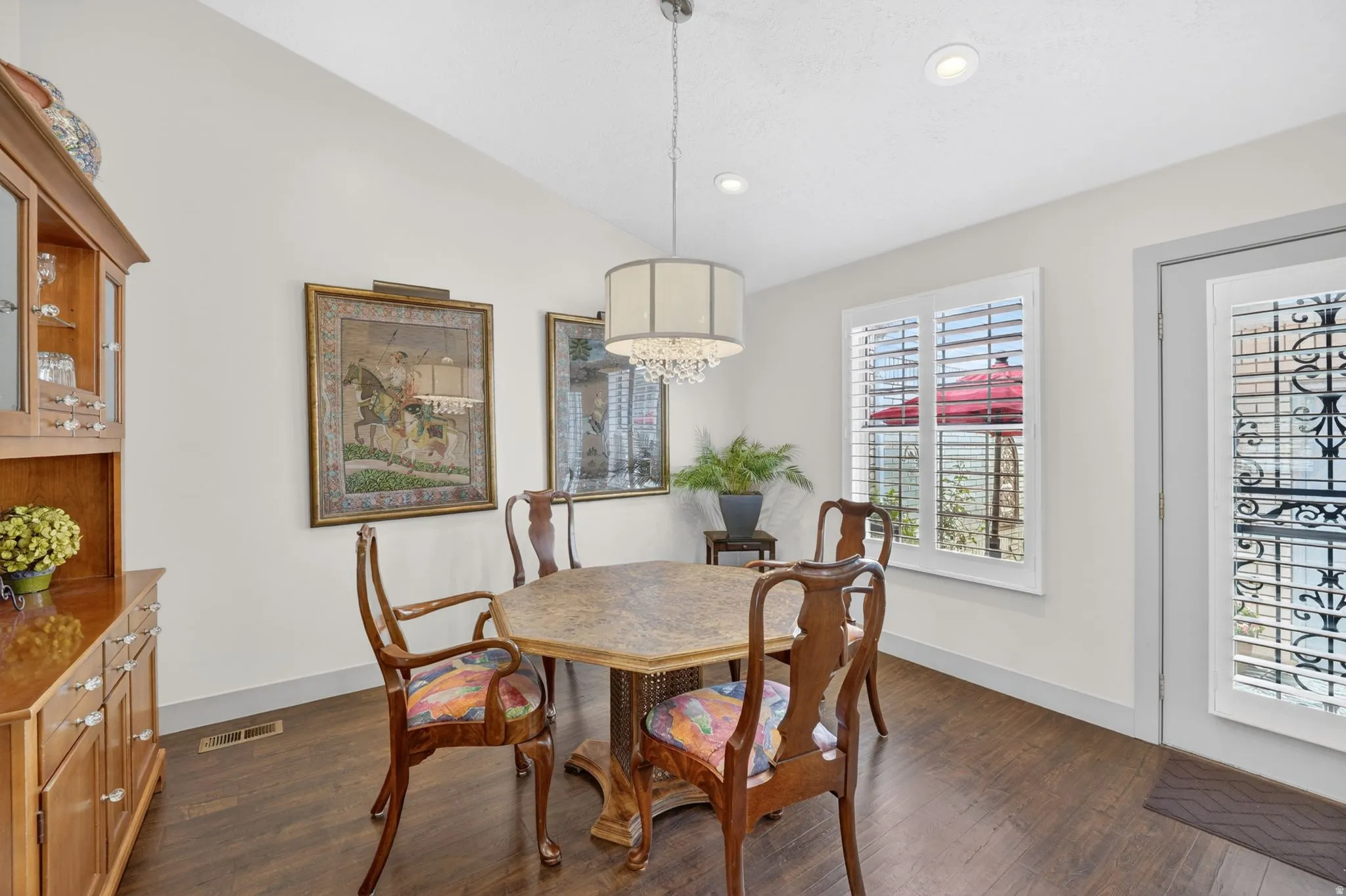 Dining space featuring dark wood-style floors, vaulted ceiling, and recessed lighting