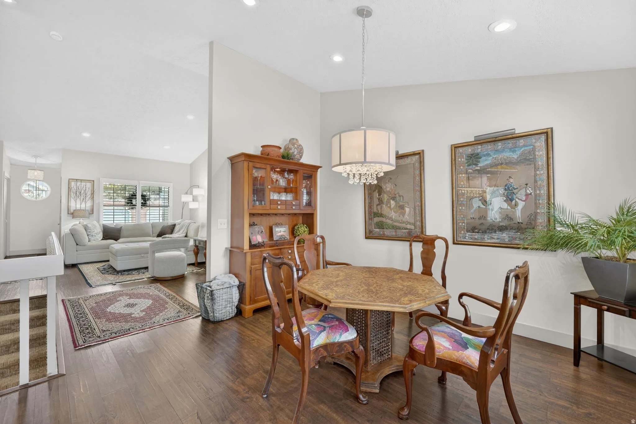 Dining area with dark wood finished floors, suspended lighting, and lofted ceiling