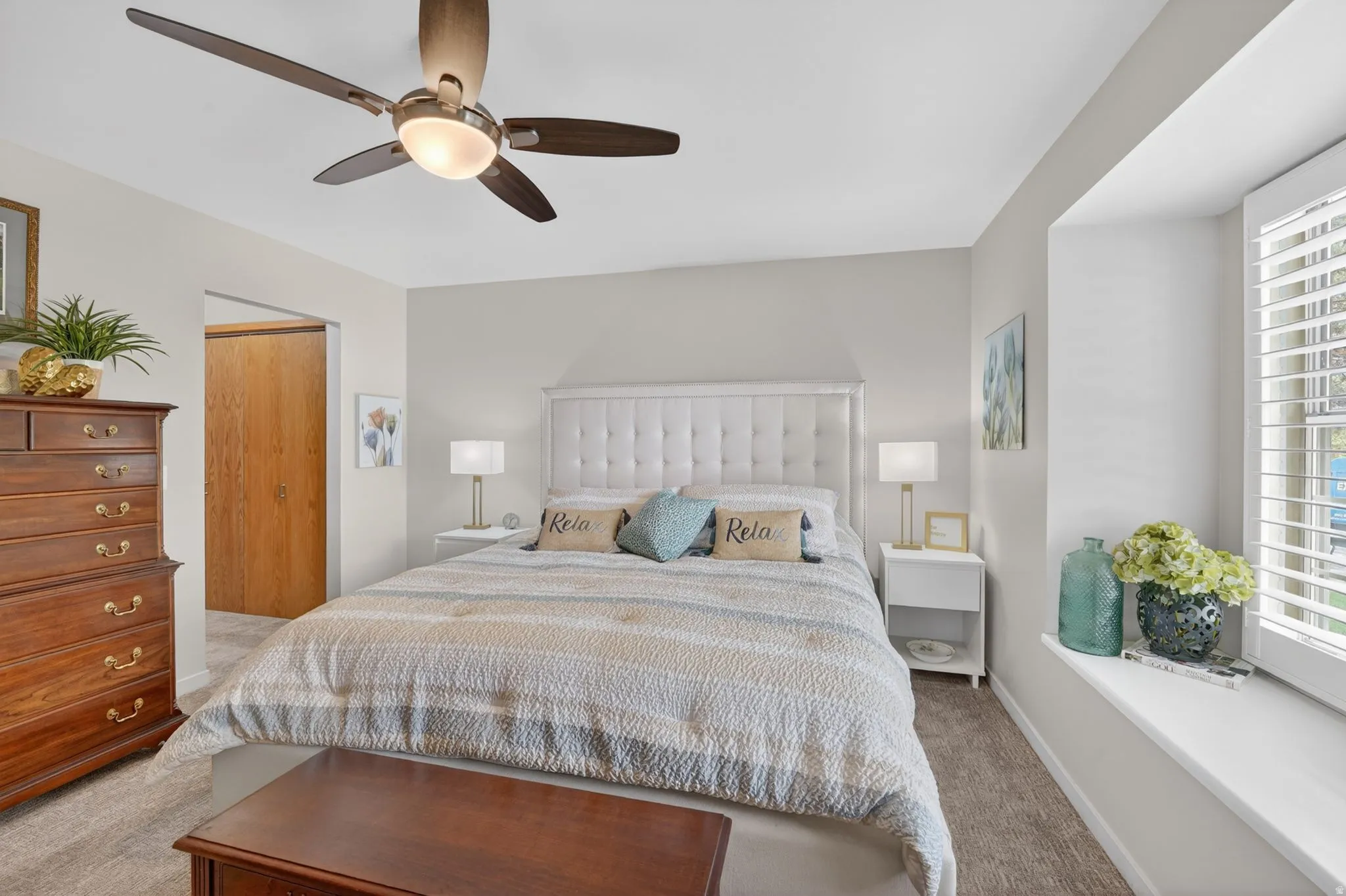 Bedroom with a closet, carpet, and ceiling fan