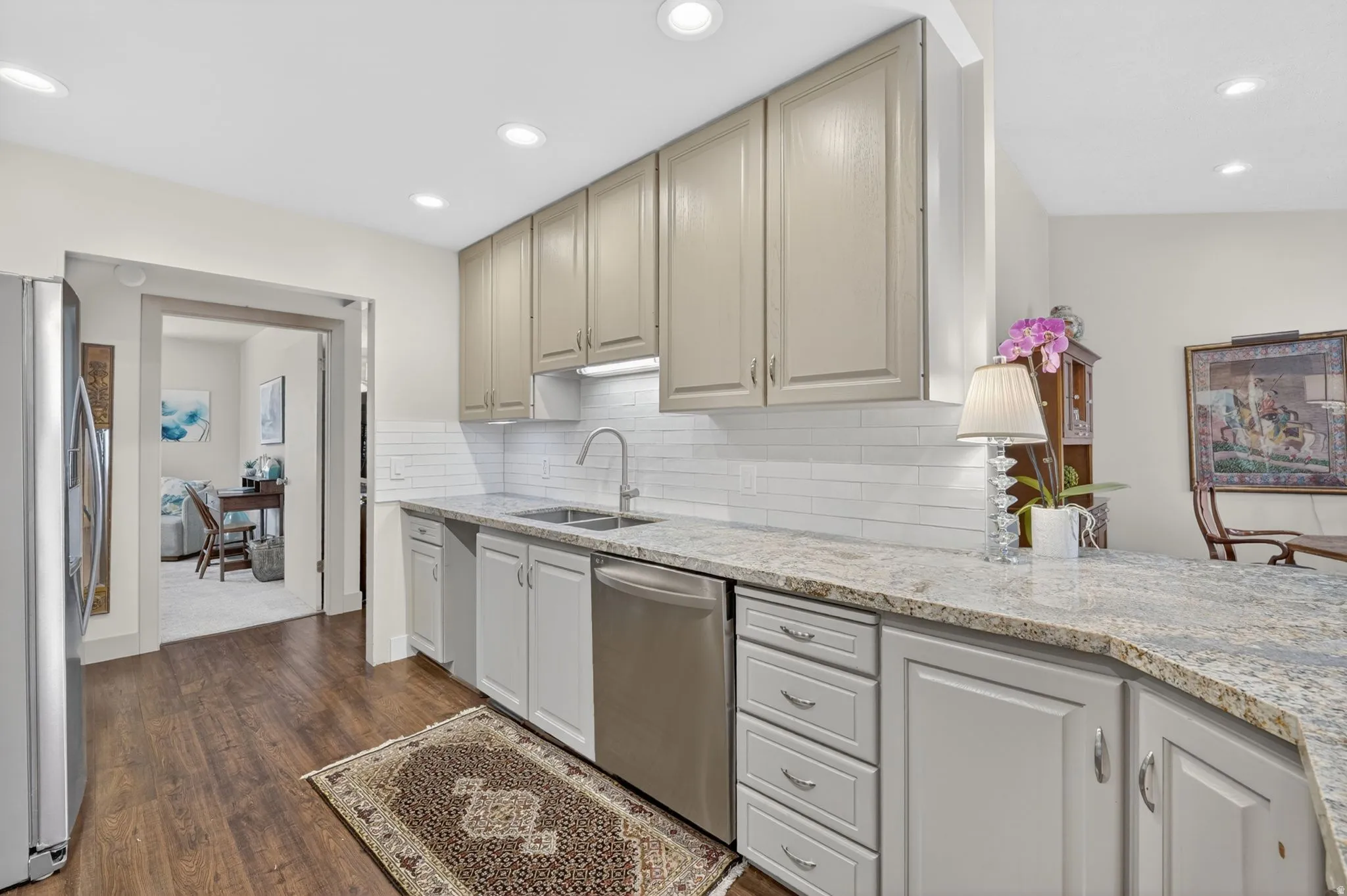 Kitchen featuring light stone counters, stainless steel appliances, dark wood-type flooring, backsplash, and recessed lighting