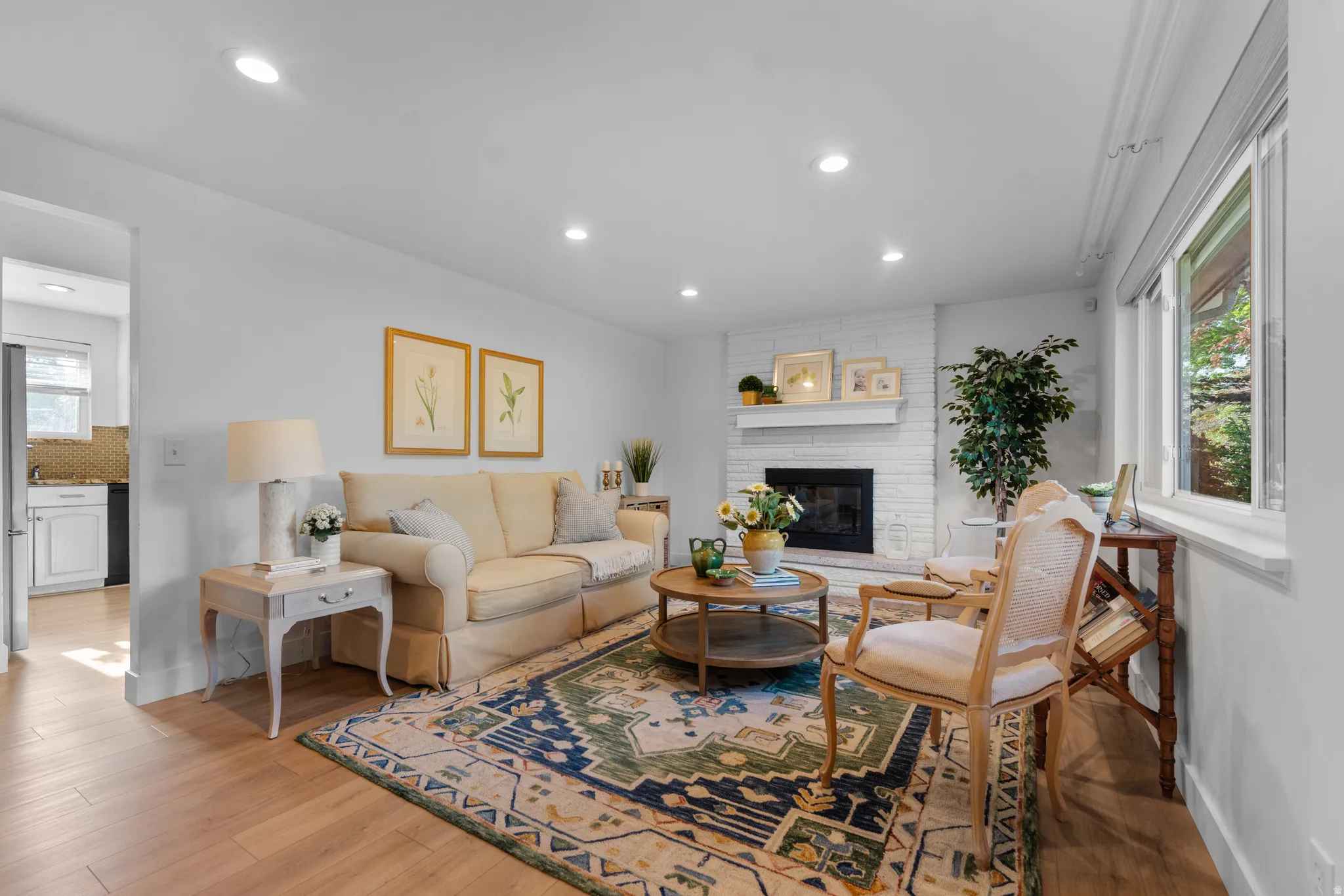 Living area featuring recessed lighting, light wood-type flooring, and a brick fireplace