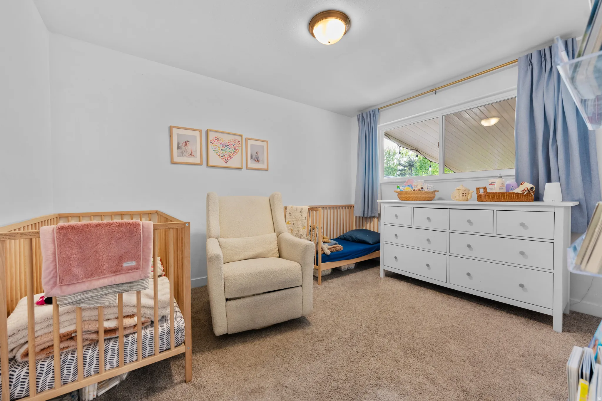 Bedroom featuring a crib and light colored carpet