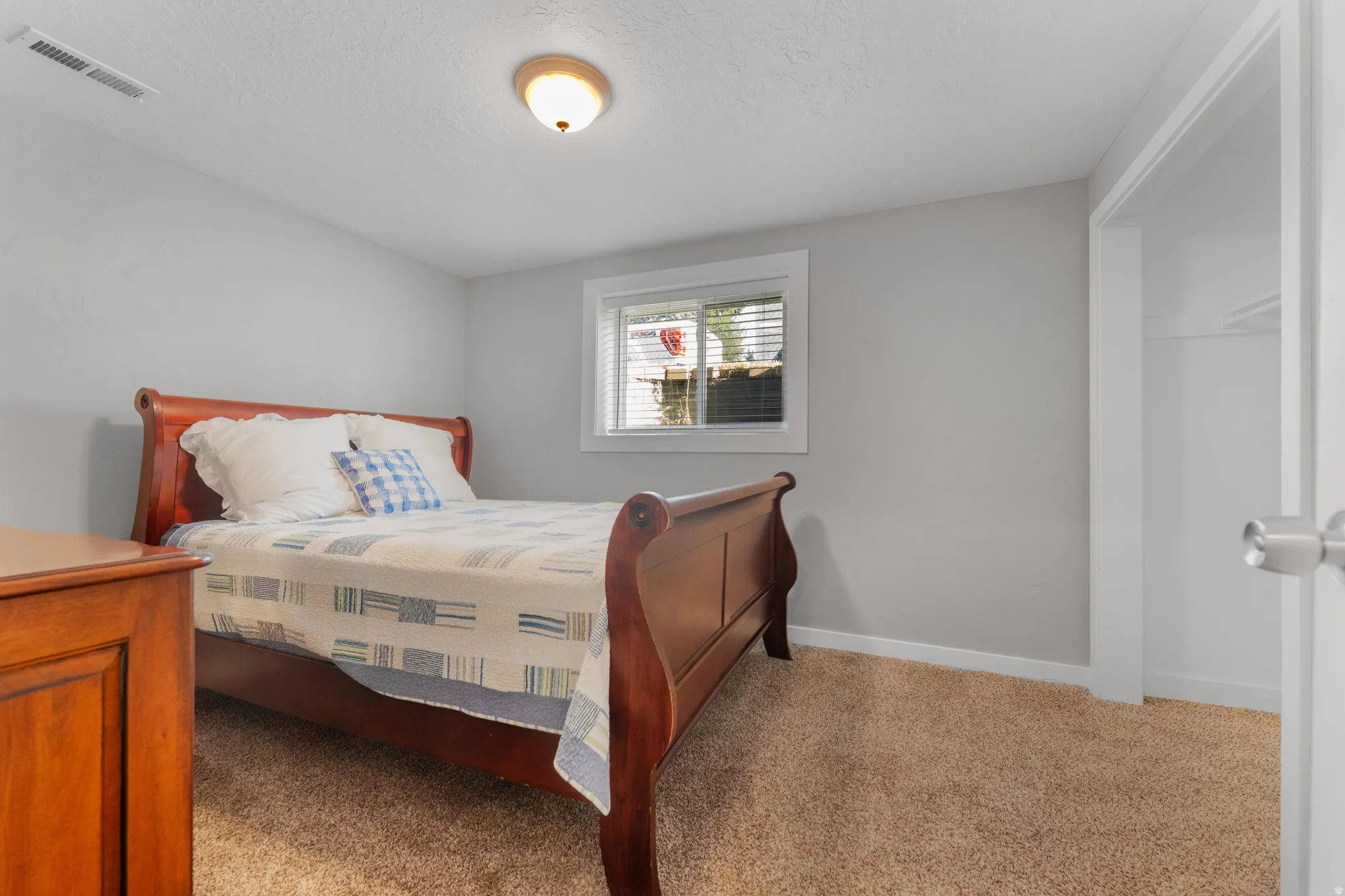 Carpeted bedroom with a textured ceiling