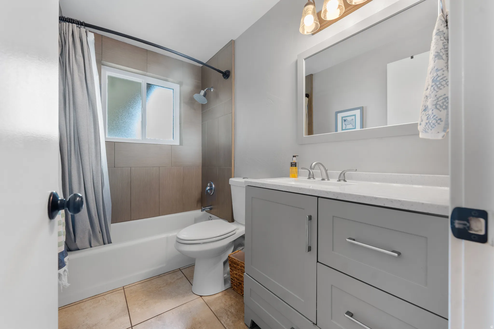 Full bath with vanity, shower / tub combo with curtain, and light tile patterned flooring