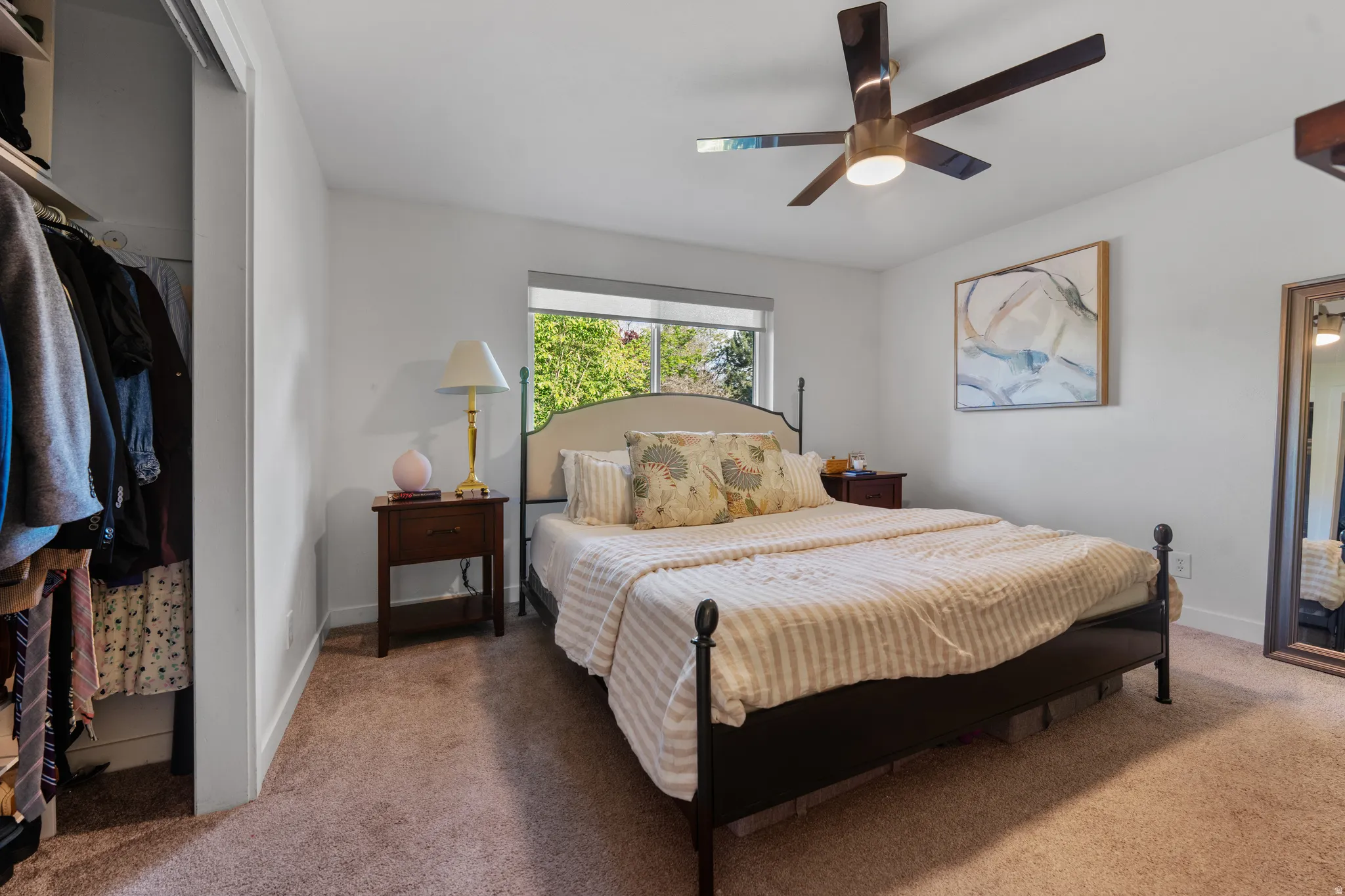 Bedroom featuring light colored carpet, ceiling fan, and a closet