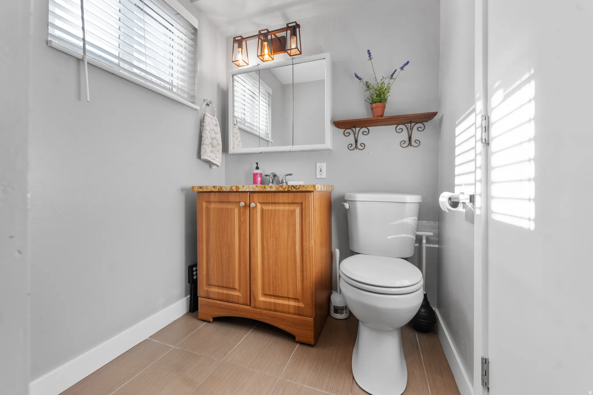 Half bath with vanity and light tile patterned flooring