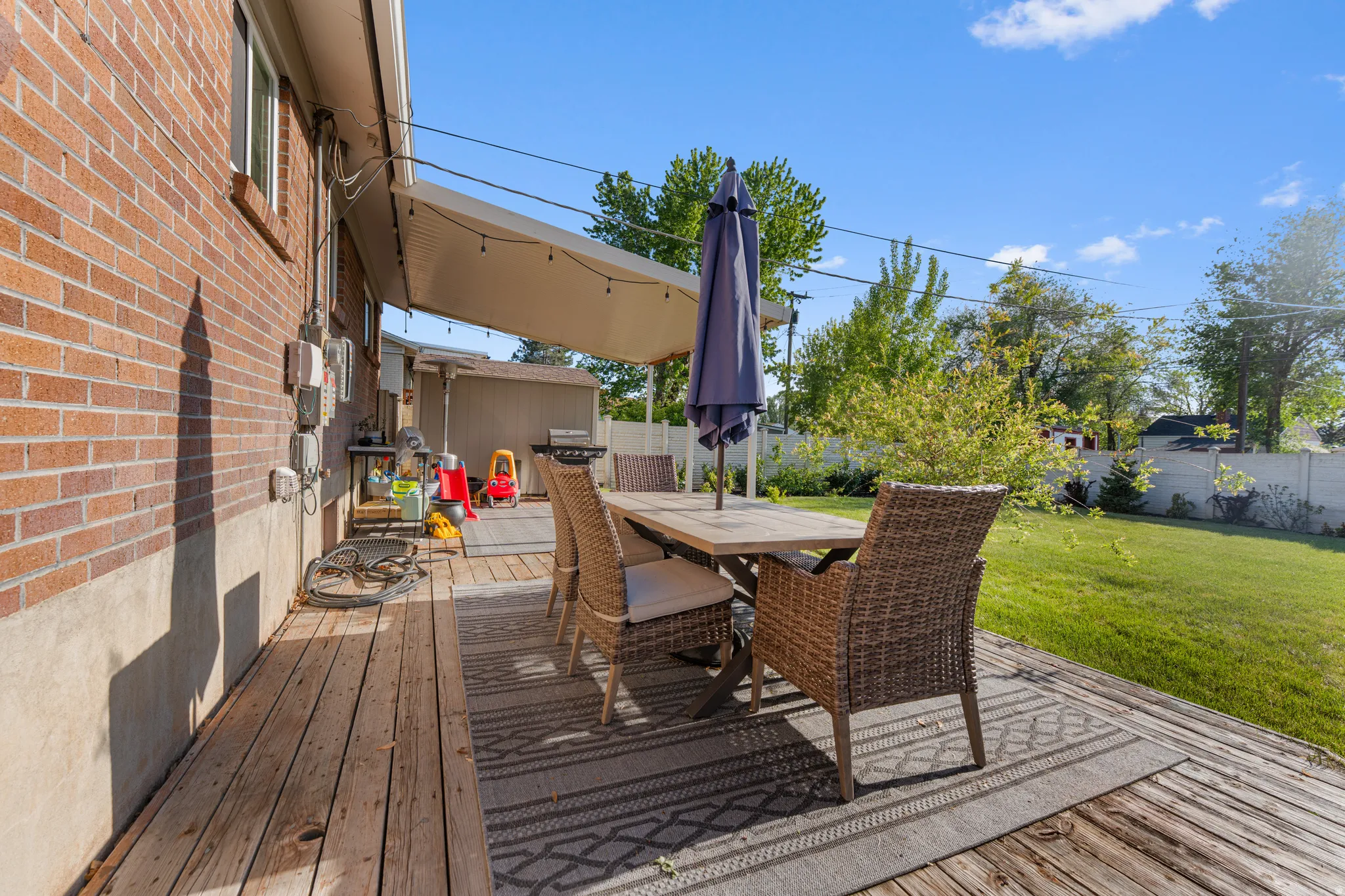 Wooden deck with outdoor dining area and a fenced backyard