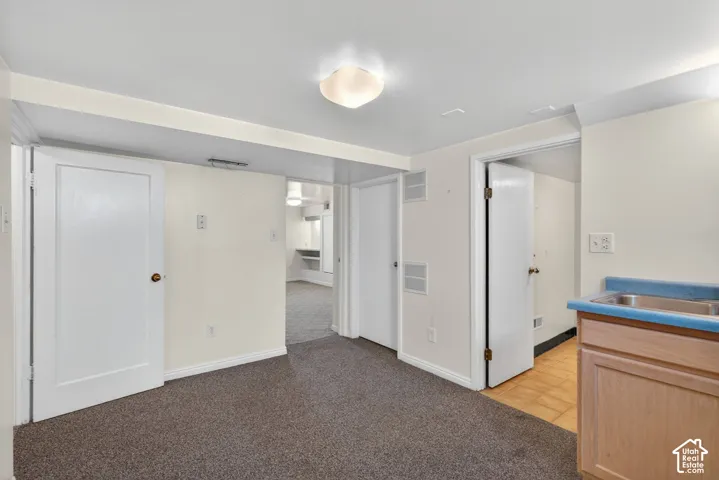 Unfurnished bedroom with light colored carpet and baseboards
