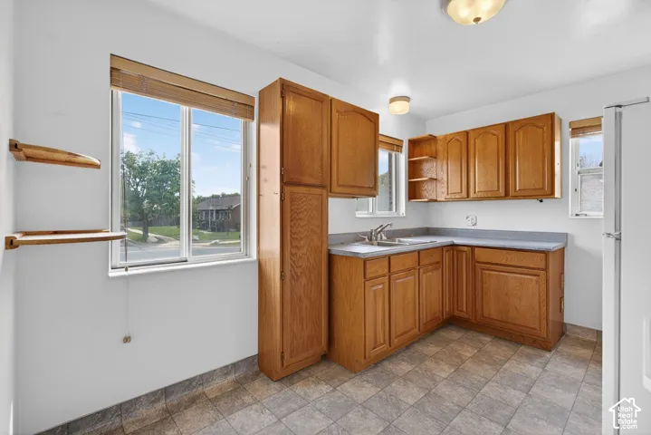 Kitchen with open shelves, stone finish flooring, and wood finish cabinetry