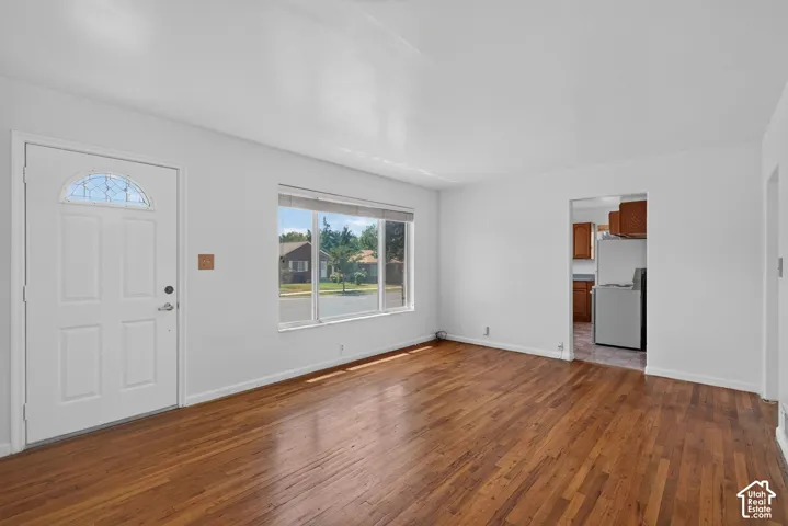 Bright living area featuring wood-finish flooring, white walls, and a multi-pane picture window