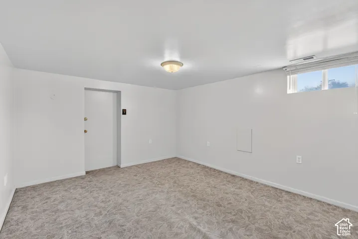 Unfurnished room featuring light colored carpet and baseboards