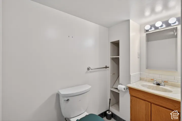 Half bath featuring vanity and backsplash