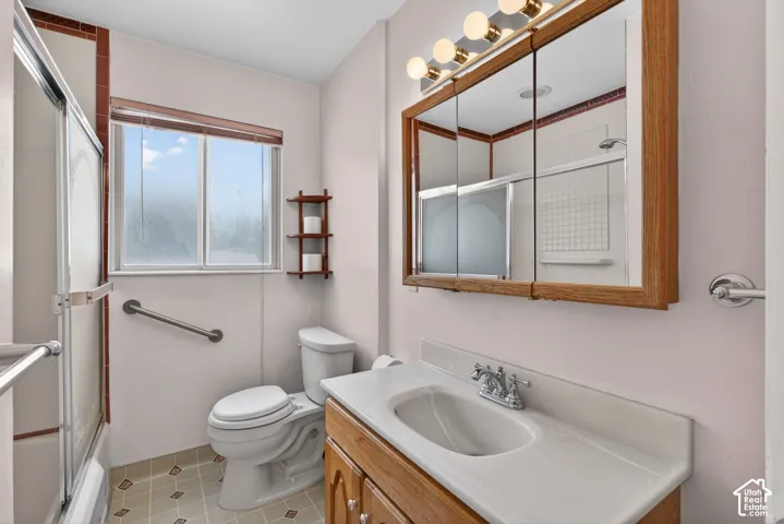 Bathroom with vanity and enclosed tub / shower combo