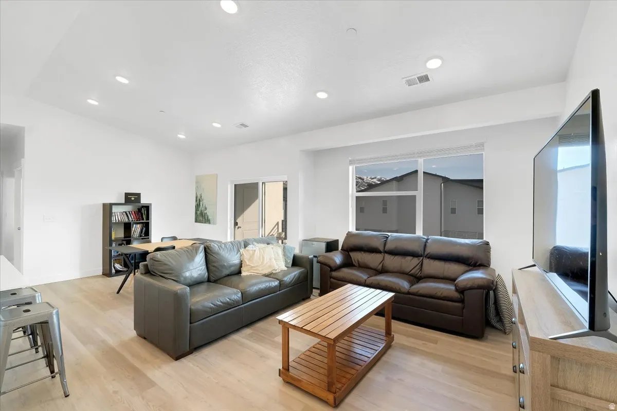 Living area featuring light wood-style floors and recessed lighting