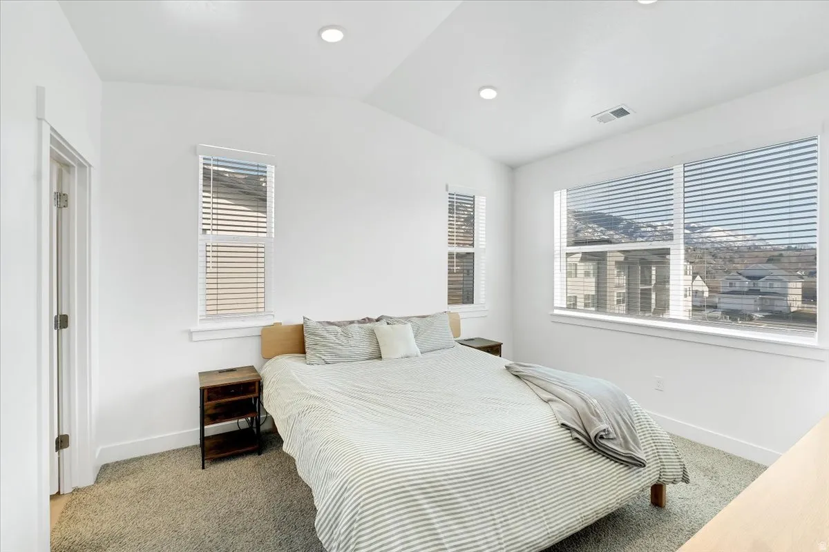Bedroom featuring carpet, lofted ceiling, and recessed lighting