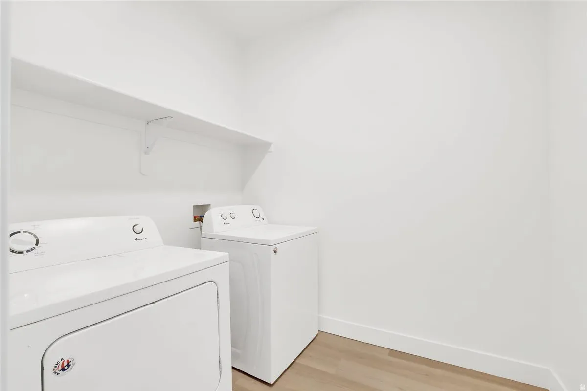 Laundry area featuring independent washer and dryer and light wood-style flooring