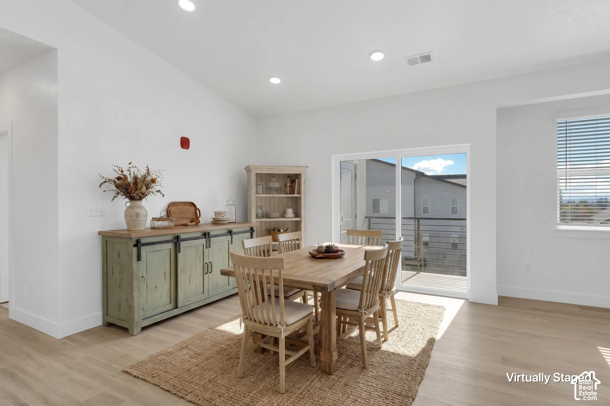 Vaulted ceilings, recessed lighting, wood-finish flooring, and sliding glass doors providing outdoor access