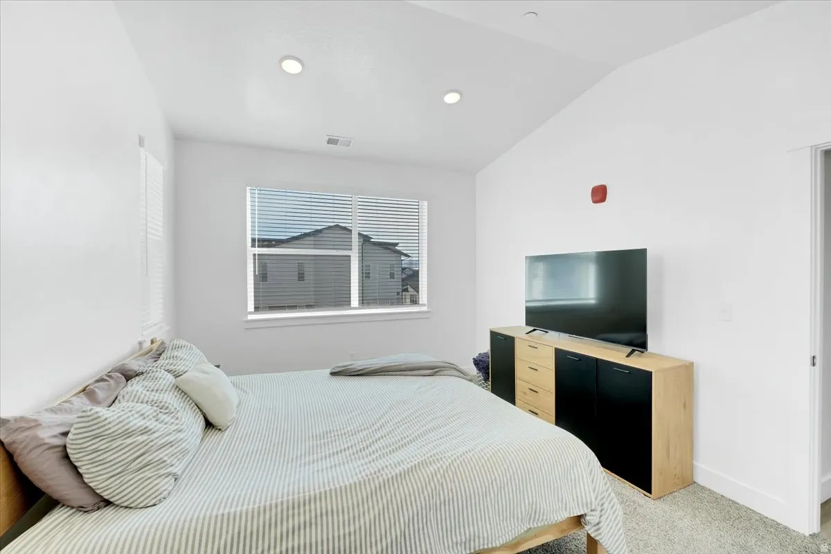 Bedroom featuring vaulted ceiling, carpet, and recessed lighting