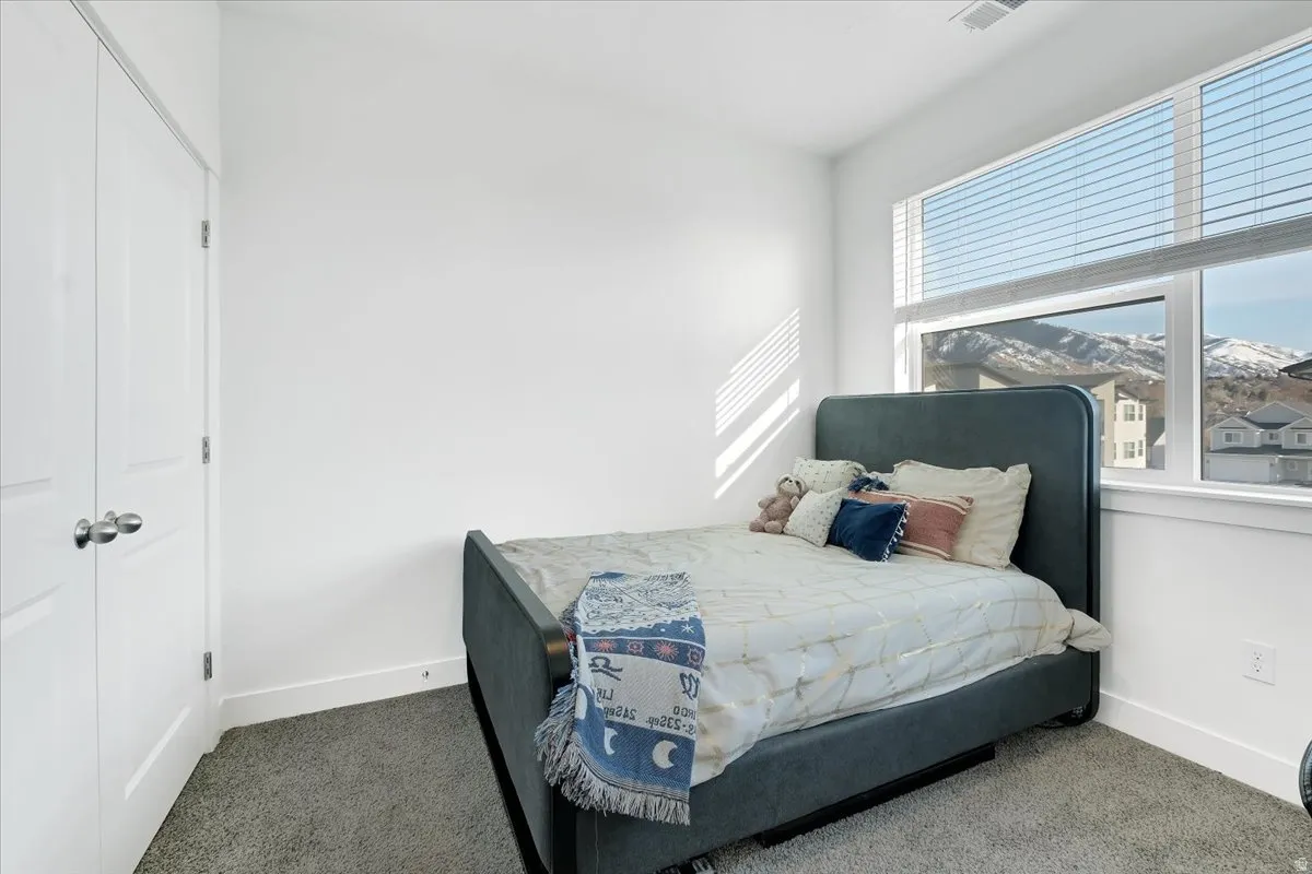 Bedroom with dark carpet and a closet