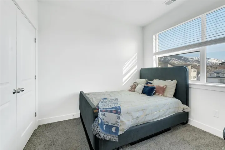 Bedroom with dark carpet and a closet