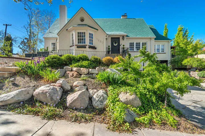 View of front of house featuring a chimney and stucco siding