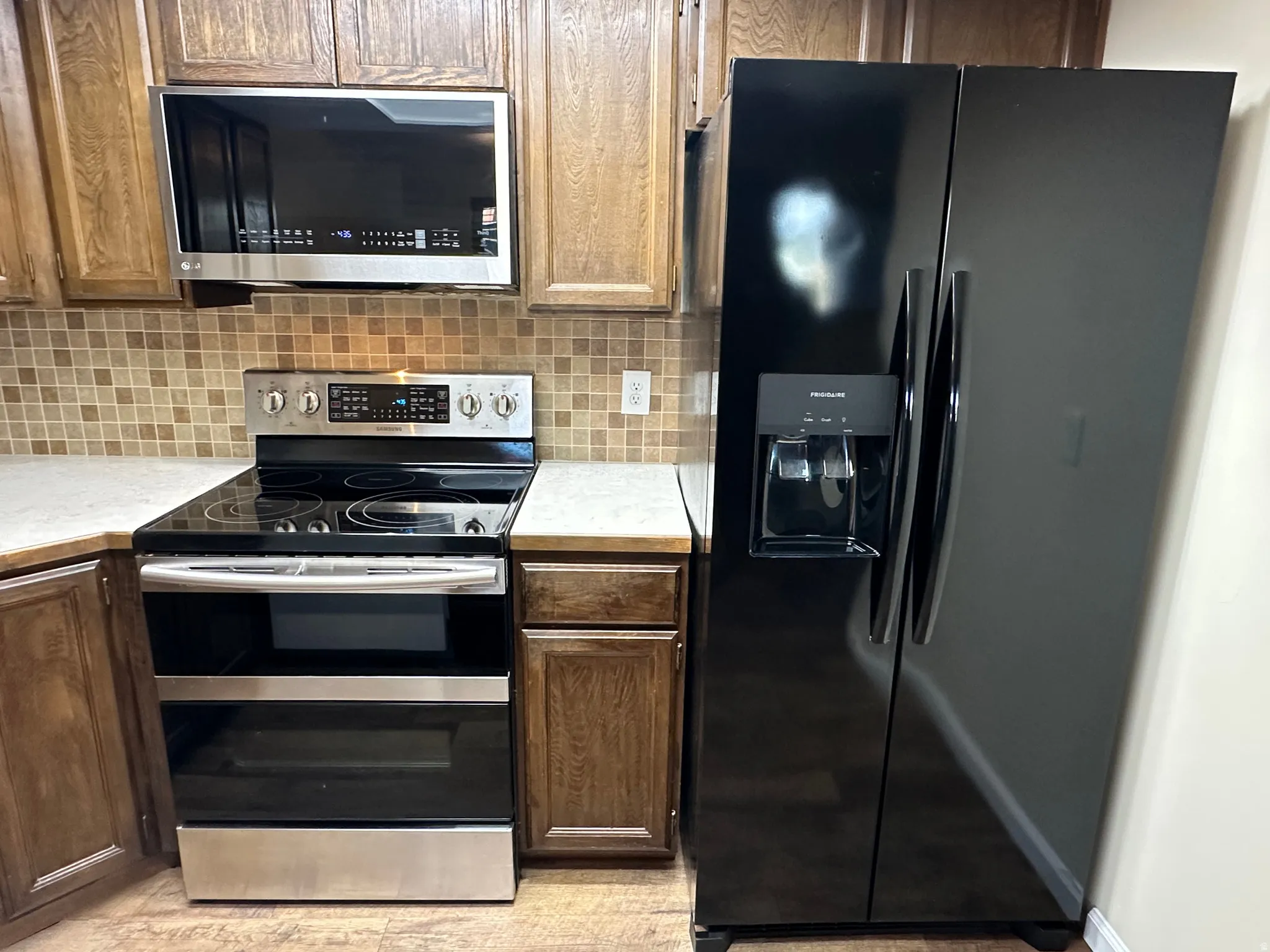 Kitchen featuring stainless steel appliances, light countertops, and backsplash