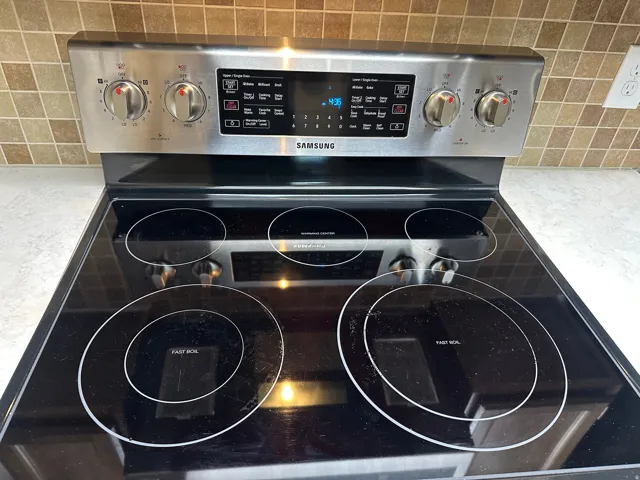 Kitchen view of tasteful backsplash and electric stove