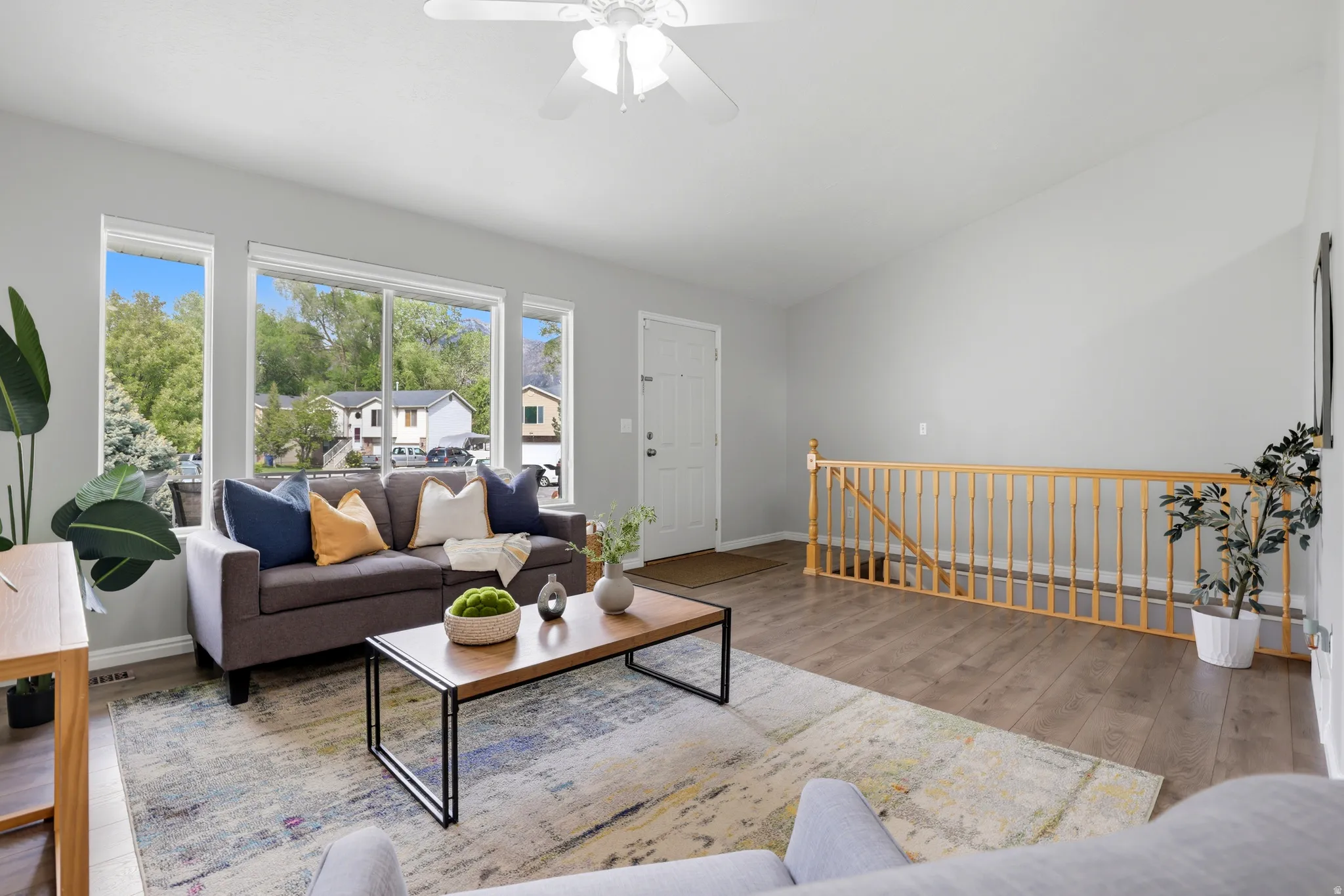 Living area featuring wood finished floors, ceiling fan, and vaulted ceiling