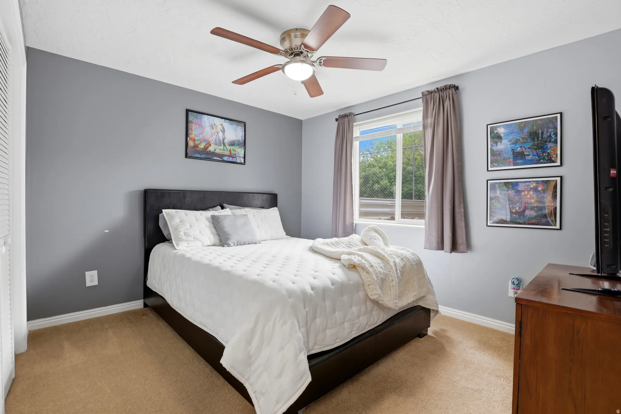Carpeted bedroom with baseboards and ceiling fan