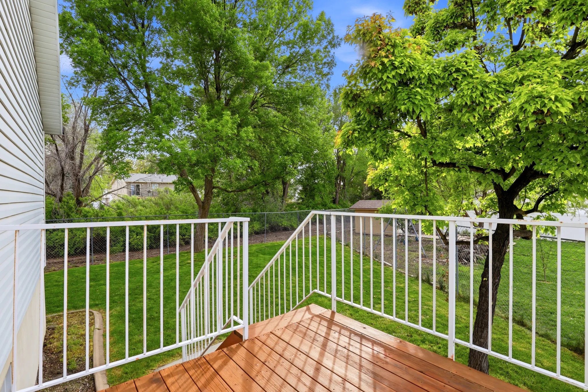 Wooden deck with a fenced backyard