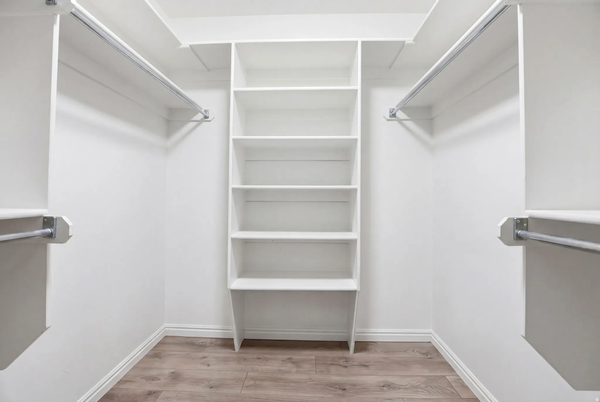 Walk in closet with light wood finished floors
