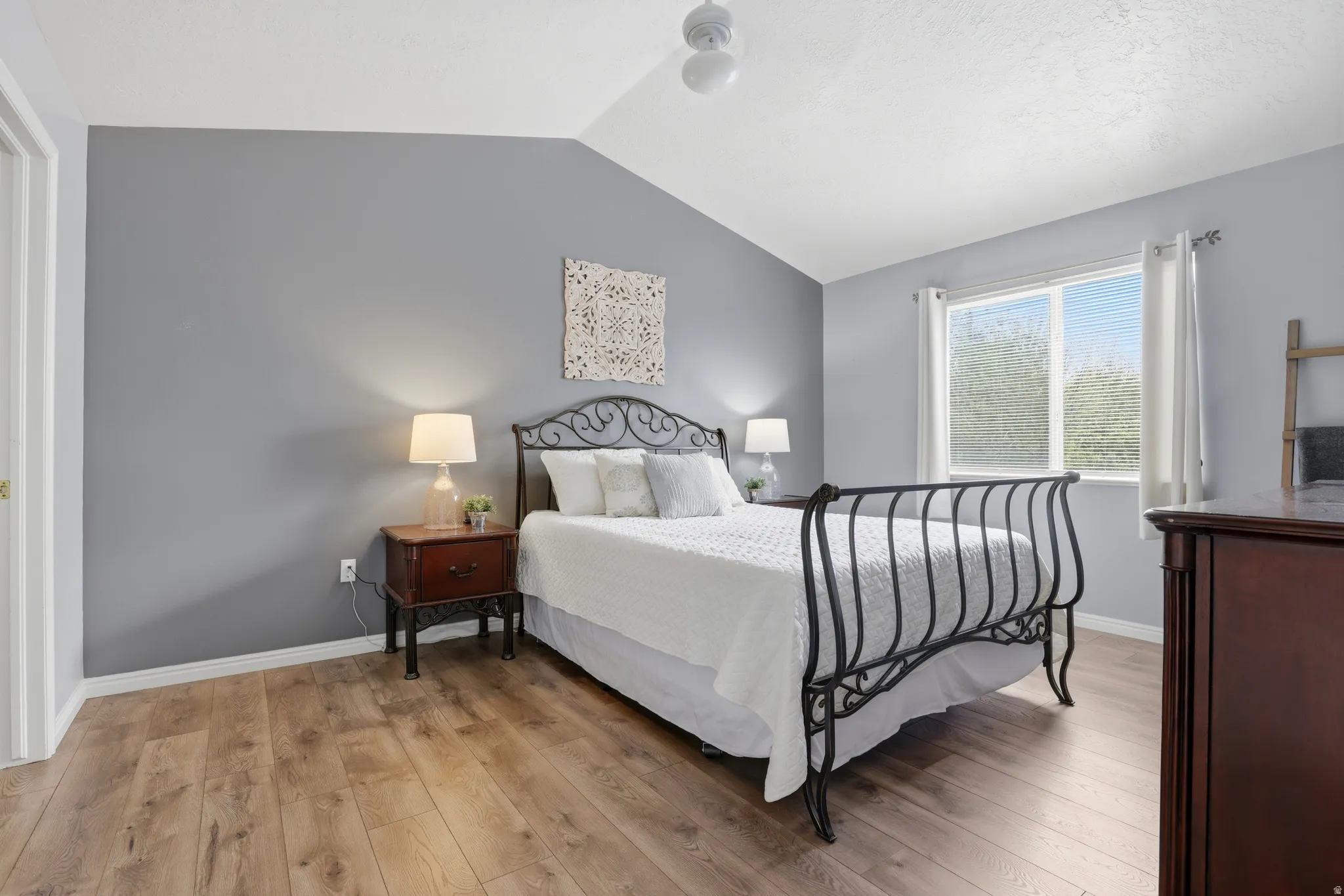 Bedroom with light wood-type flooring and lofted ceiling