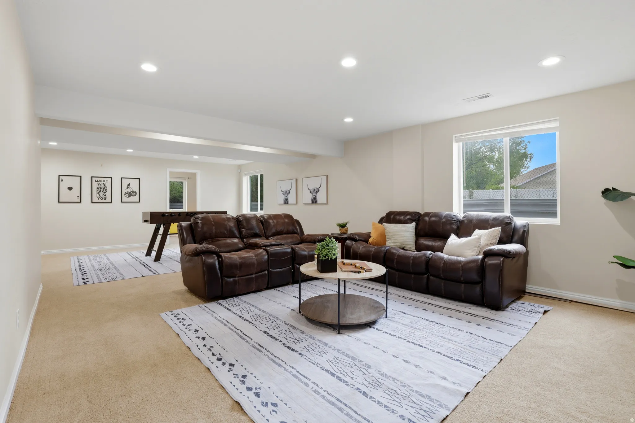 Living area with light colored carpet and recessed lighting