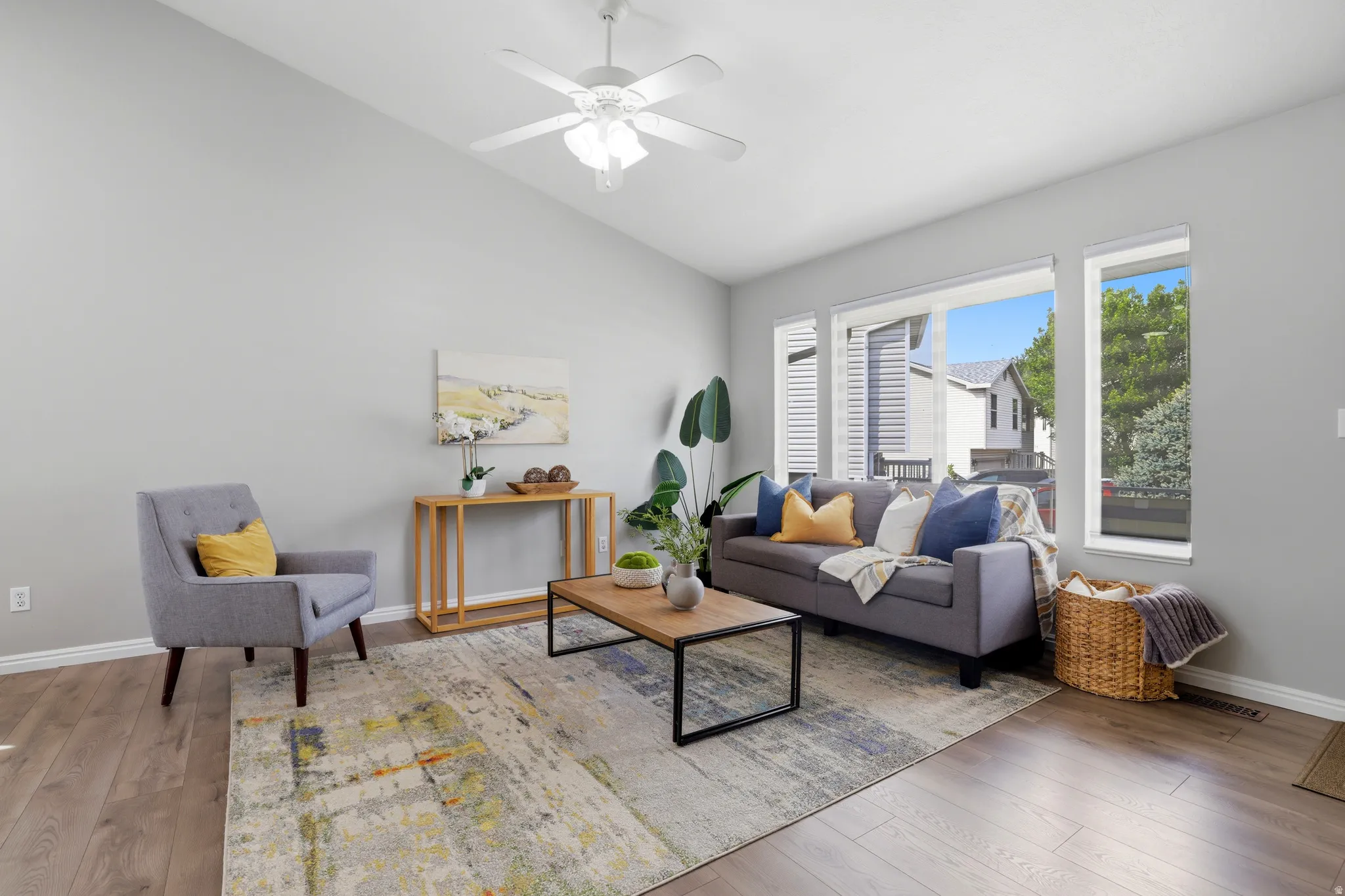 Living area featuring lofted ceiling, wood-type flooring, and ceiling fan