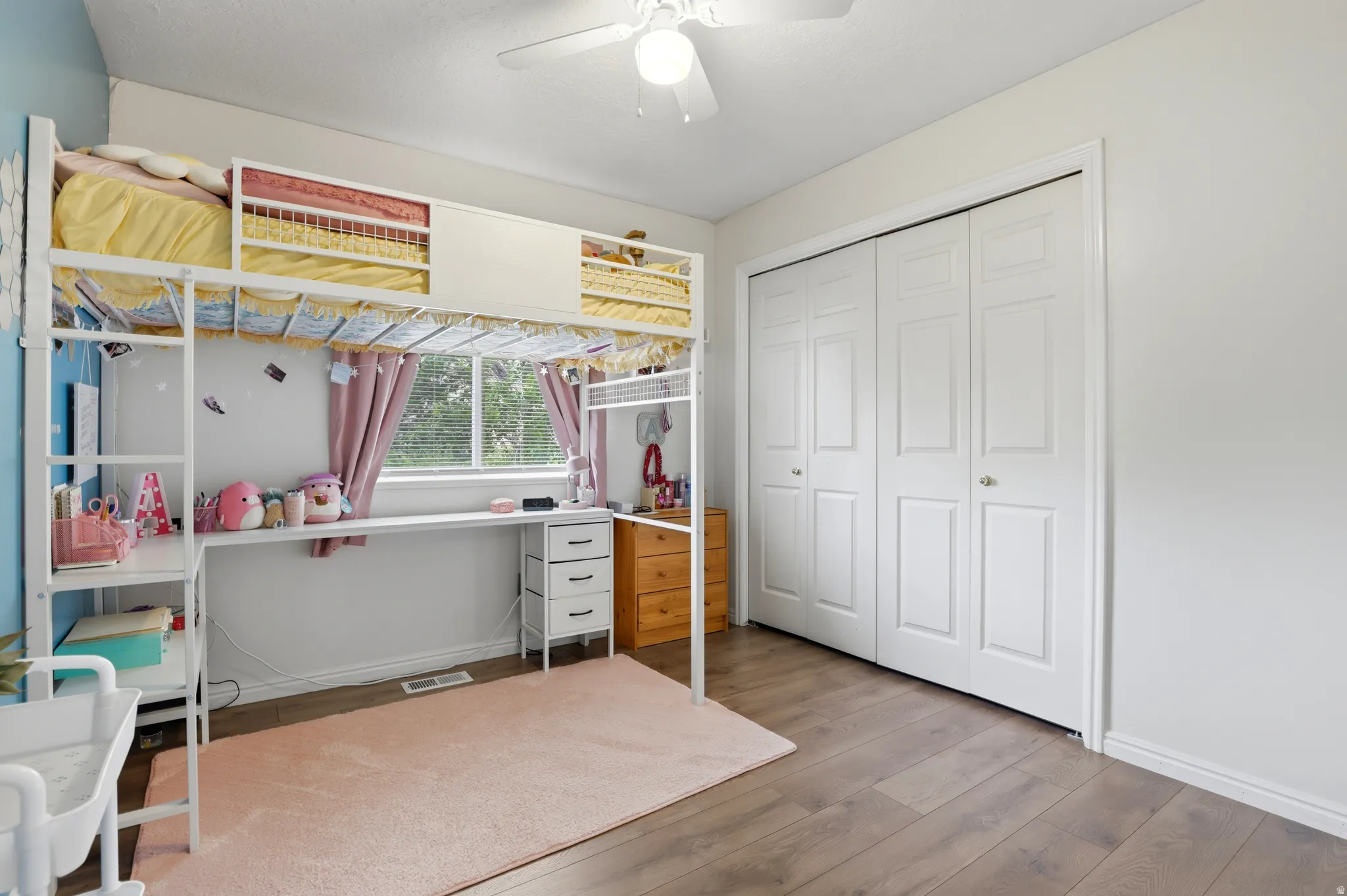 Bedroom featuring hardwood / wood-style floors, a ceiling fan, and a closet