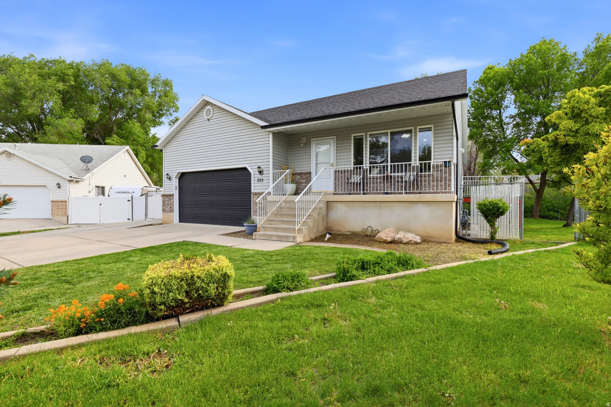 View of front facade with a porch, a gate, concrete driveway, a shingled roof, and a garage