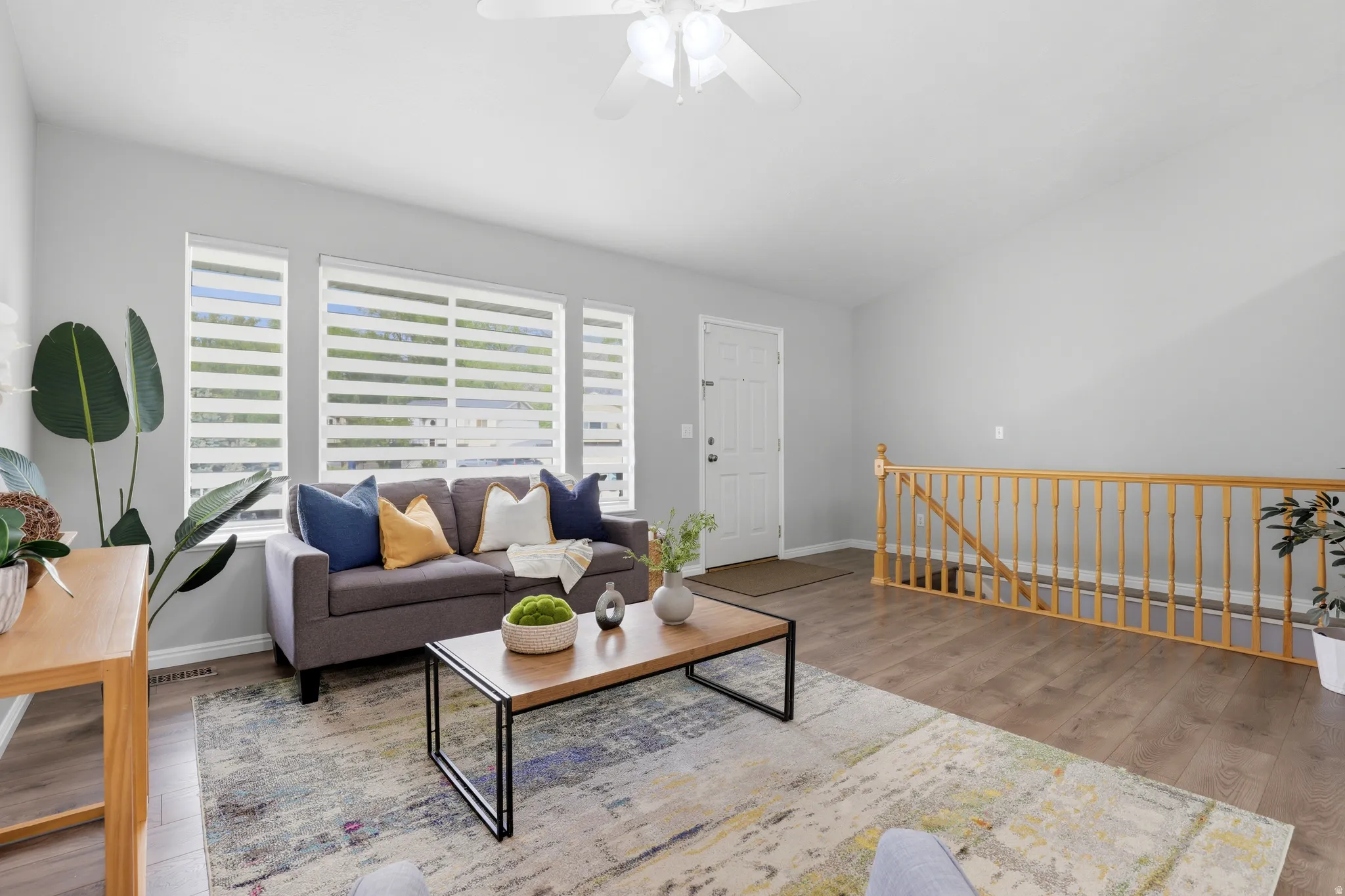 Living area with wood finished floors, a ceiling fan, and vaulted ceiling