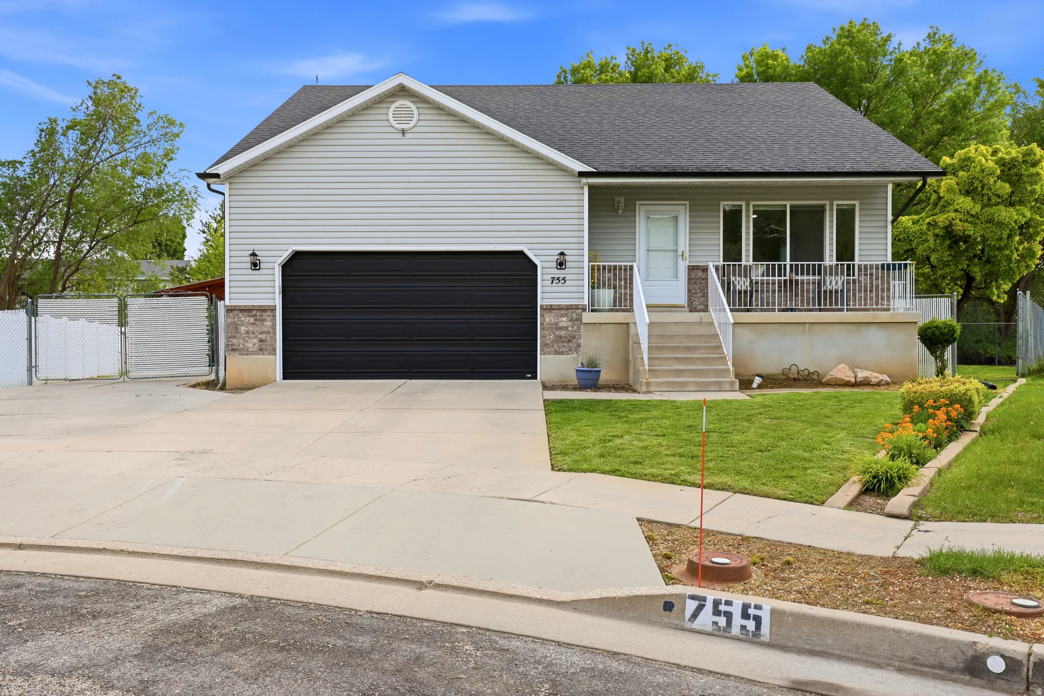 Ranch-style house featuring a porch, driveway, a shingled roof, a garage, and a gate